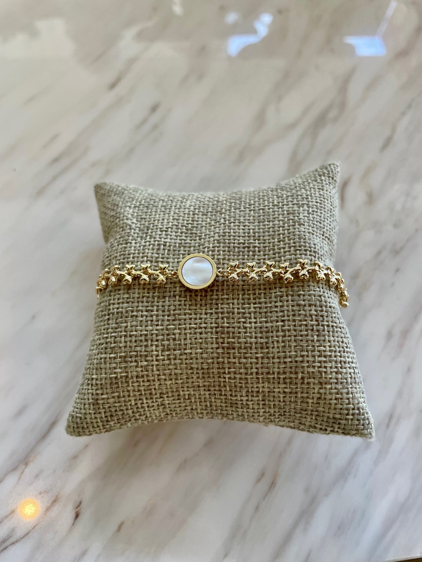 Gold chained bracelet with white circle pendant